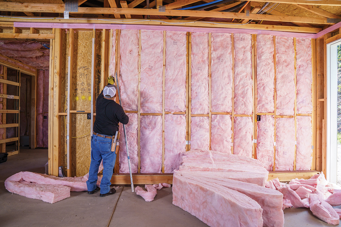 worker installing insulation into home
